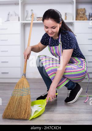 Young mistress sweeping floors Stock Photo