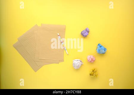 crumpled paper ball and notepad on yellow background  Stock Photo