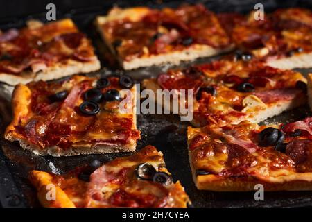 Homemade pepperoni pizza in a tray on a wooden board Stock Photo