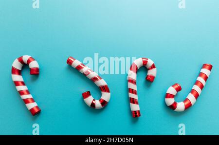 Christmas candy canes on blue background. Peppermint red white candies, Merry Xmas greeting card, winter holidays concept Stock Photo
