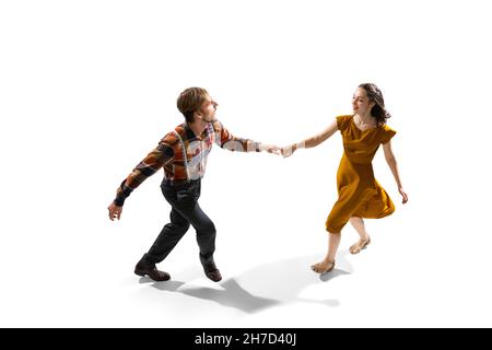 Two people, young man and woman in vintage attire dancing rock-and-roll isolated on white background Stock Photo