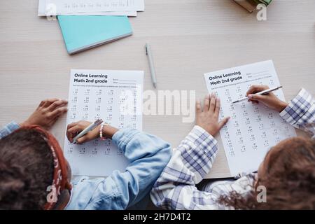 Top view portrait of two African-American girls doing homework while sitting at desk in school Stock Photo