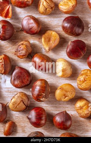 Baked chestnuts, overhead flat lay shot on a rustic wooden background