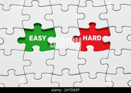 Missing puzzle pieces with the words easy versus hard. To make a choice between the options of easy or hard way concept. Stock Photo