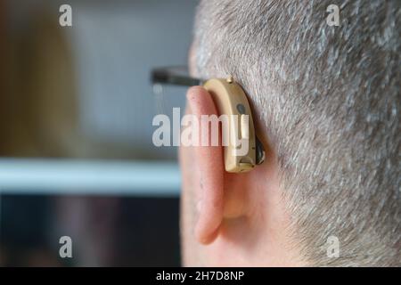 Close-up of a hearing aid placed in the ear of a deaf man Stock Photo
