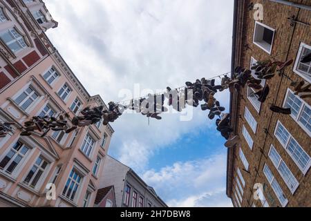 Flensburg: hanging shoes on Norderstrasse in downtown Flensburg, Shoefiti in Ostsee (Baltic Sea), Schleswig-Holstein, Germany Stock Photo