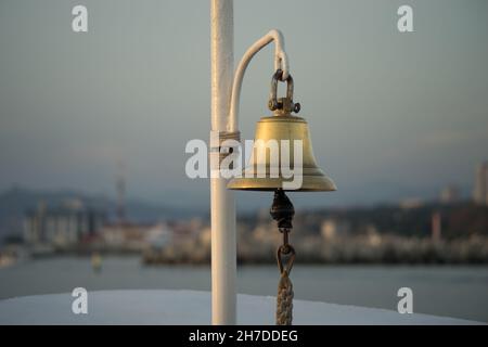 copper bell on the yacht on the background of eroded shoreline Stock Photo