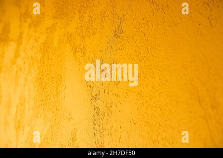 Golden wall plaster closeup. Decorative Venetian plaster. Stock Photo