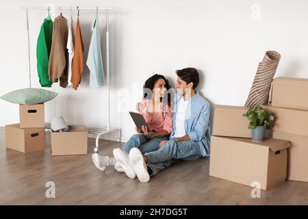 Happy millennial couple using digital tablet after relocation Stock Photo