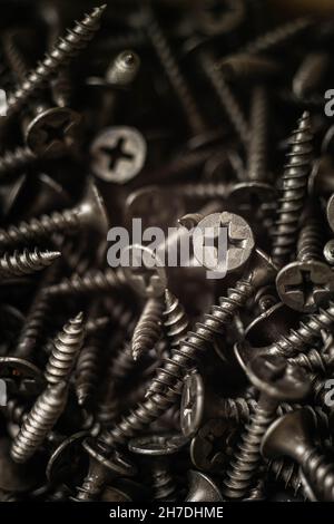 Pile of new black self-tapping screws closeup. Stock Photo