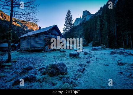 View of an old wooden forester's or hunter's lodge, Dachstein glacier and Gosaukamm mountain range in the background, Gosau, Salzkammergut, Austria Stock Photo