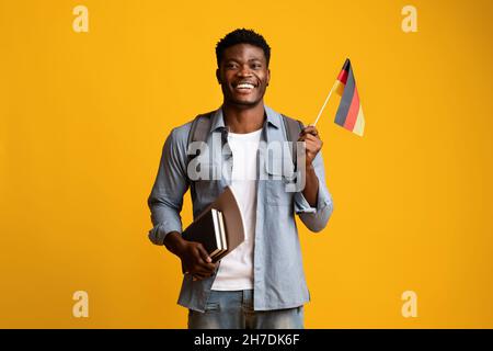 Happy black guy student showing flag of Germany Stock Photo
