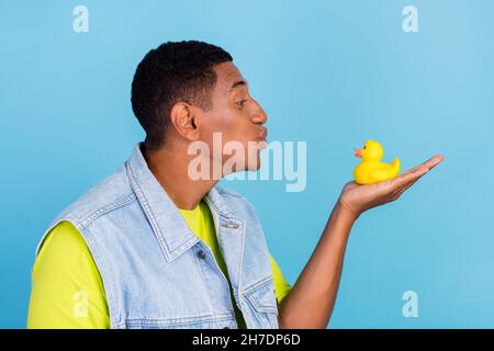 Profile side photo of young african man plump lips send kiss duck playful isolated over blue color background Stock Photo