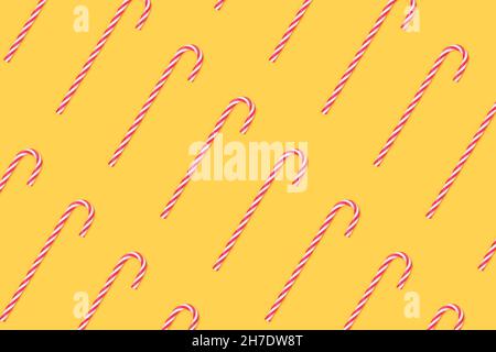Repetitive pattern made of candy canes on a yellow background. Stock Photo