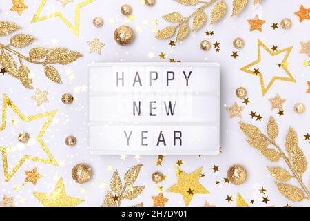 Happy New Year. Lightbox and golden decorations on a blue background. Stock Photo