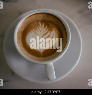 cup of cappuccino on a table with latte art Stock Photo