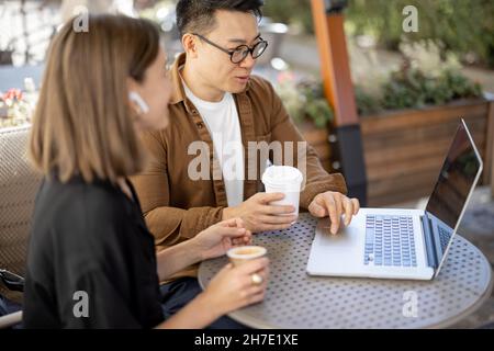 People talking and working with laptop in cafe Stock Photo