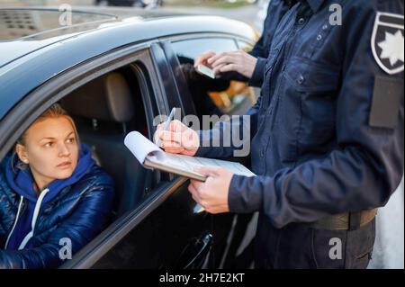 Police patrol checking driver's license of driver Stock Photo