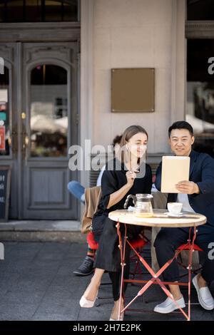 People having video call on digital tablet at cafe Stock Photo