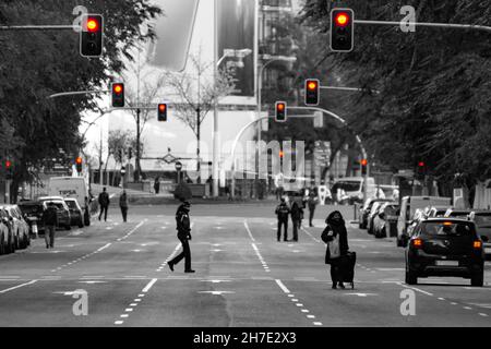 Streets, roads and highways of Madrid empty of cars while some people walk with the traffic lights on, in Spain. Europe. Horizontal photography.