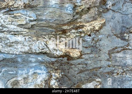 Surface of a marble stone lying on the road in the Ruskeala Mountain Park for use as an abstract background and textures. Stock Photo