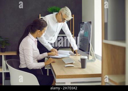 Two business colleagues doing some paperwork while working together in the office Stock Photo