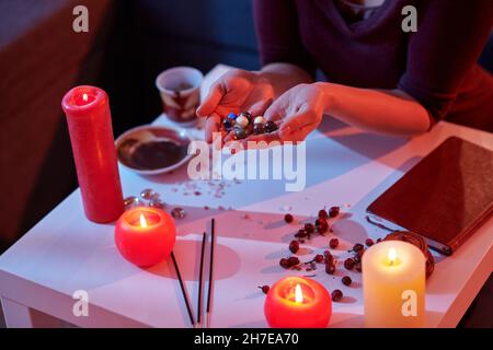 Caucasian female fortune-teller holding seven chakra stones Stock Photo