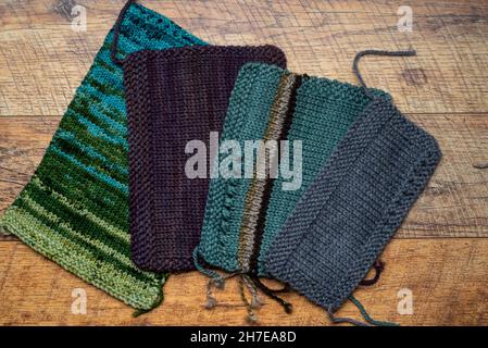 Top view of knitted swatches yarns on brown wooden background. Stock Photo