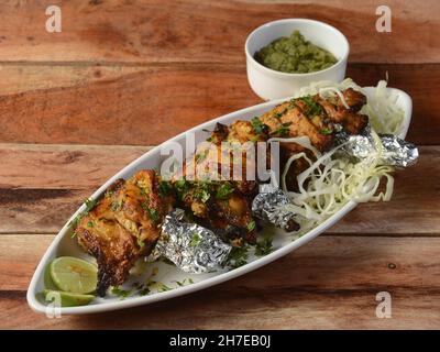 Murgh kalmi kebab on wooden background. Dishes and appetizers of indian cuisine, selective focus Stock Photo