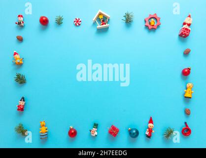 Xmas minimal vintage greeting card template. Christmas decoration frame, baubles and ornaments on blue color background, copy space. Stock Photo