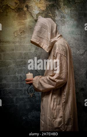 Tall man with long priest dress with stone old wall Stock Photo