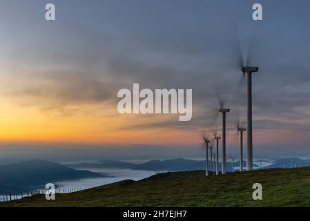 Wind turbines farm at sunrise, Oiz mountain, Basque Country, Spain Stock Photo