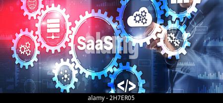 SaaS Software as a Service concept with hand pressing text. Stock Photo