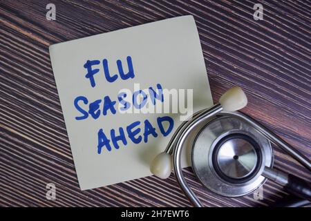 Flu Season Ahead write on sticky notes isolated on Wooden Table. Stock Photo