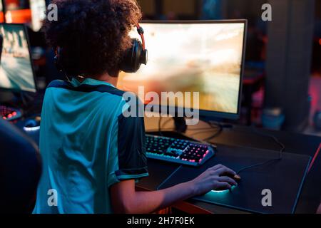 Competitive female gamer plays online game in internet club Stock Photo