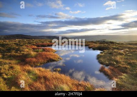 Sunset on Stanage Edge in the Peak District National Park. Reflections of the sky in standing water mirror the scene.