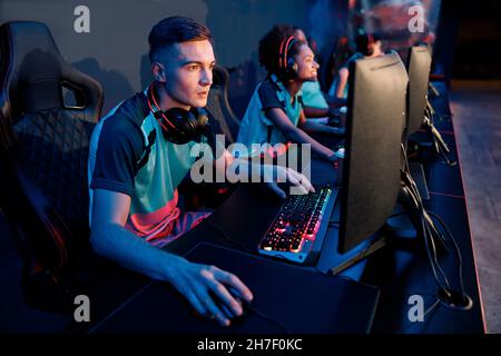 Esports team playing game on computers in gaming club Stock Photo