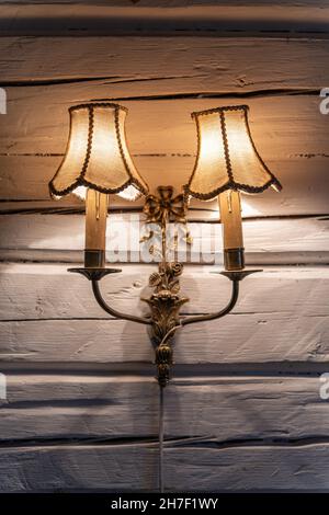 Old vintage bronze double lamp on the white wooden wall Stock Photo