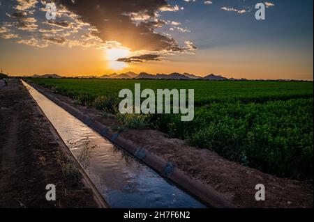 Irrigation canal or water channel in Tucson, Arizona next to farmland Stock Photo