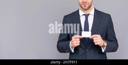 cropped businessman hold credit card with copy space on grey background, banking Stock Photo