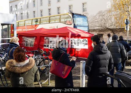 Berlin, Germany. 22nd Nov, 2021. People line up to get inoculated with COVID-19 vaccines in front of a vaccination bus in Berlin, capital of Germany, Nov. 22, 2021. Berlin has launched vaccination buses in batches in a variety of locations of the city to help people get vaccinated. Credit: Stefan Zeitz/Xinhua/Alamy Live News Stock Photo