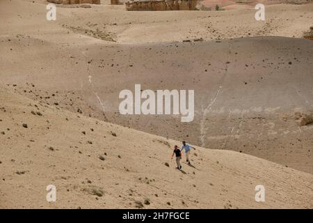 Two guys walking in desert and lost their way in hill and desert sand in wild Stock Photo