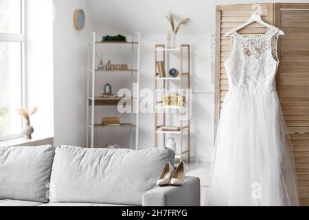 Beautiful wedding dress prepared for ceremony in living room Stock Photo