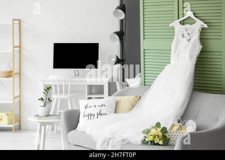 Wedding dress, shoes and bouquet prepared for ceremony in room Stock Photo