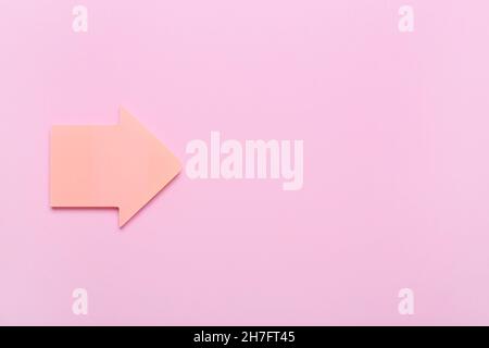 Sticky note papers in shape of arrow on pink background Stock Photo