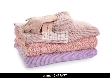 Stack of stylish sweaters, gloves and hat on white background Stock Photo