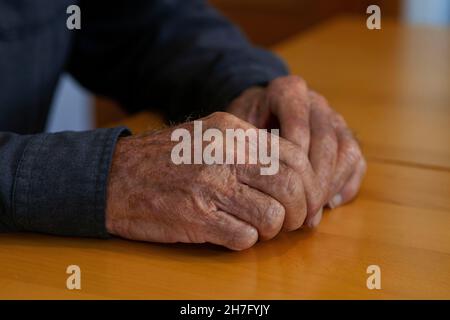 A close up of the hands of an elderly man's hands clasping together MR - Model Released Stock Photo