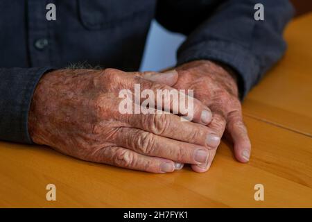 A close up of the hands of an elderly man's hands clasping together MR - Model Released Stock Photo