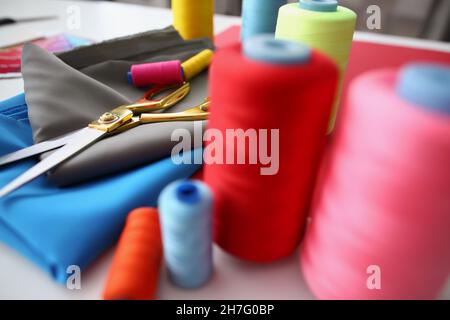Composition of sewing accessories scissors and threads on fabric Stock Photo
