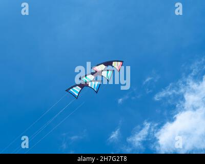 Stack of three quad line stunt kites against a blue sky. Stock Photo